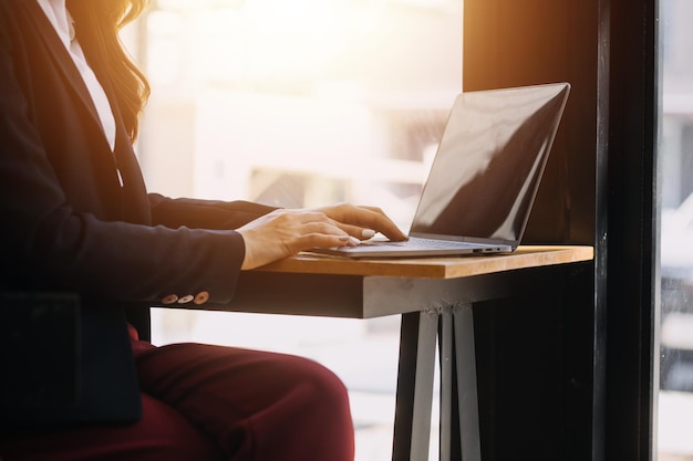 Foto de uma jovem empresa asiática trabalhando em um laptop em sua estação de trabalho