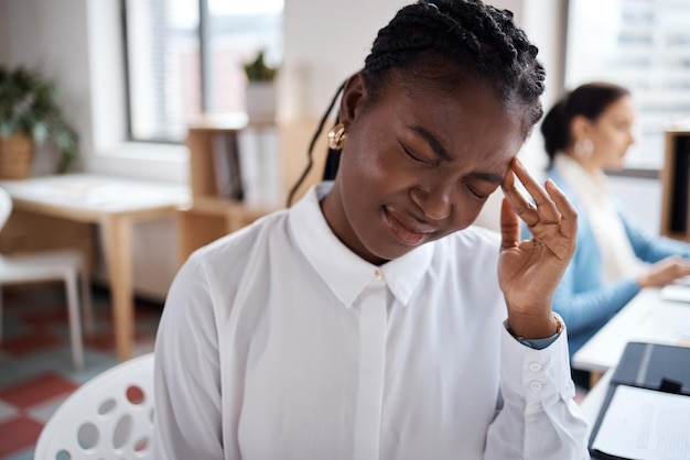 Foto de uma jovem empresária parecendo estressada enquanto trabalhava em sua mesa em um escritório moderno