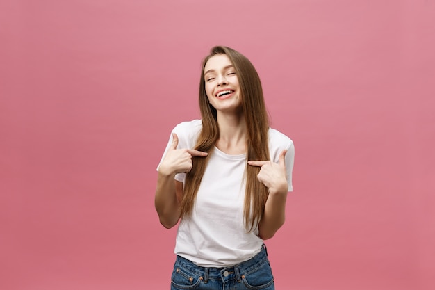 Foto de uma jovem feliz em pé e apontando o dedo