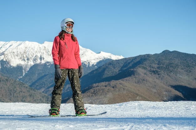 Foto de uma jovem feliz snowboarder nas encostas do resort de inverno