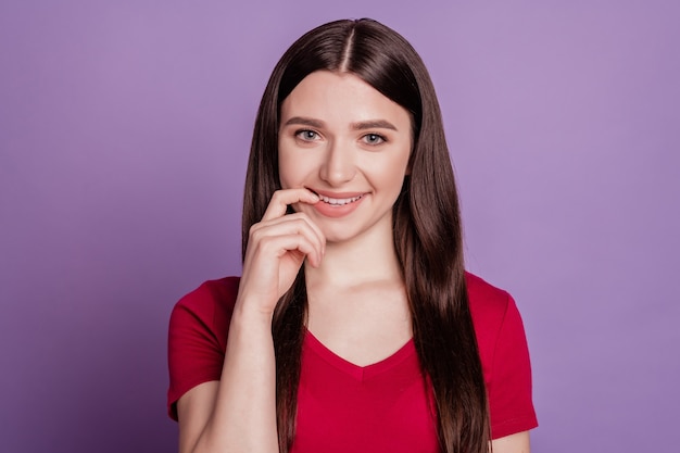 Foto de uma jovem garota atraente com os dedos tocando os dentes, um sorriso feliz e feliz, isolado sobre um fundo de cor violeta