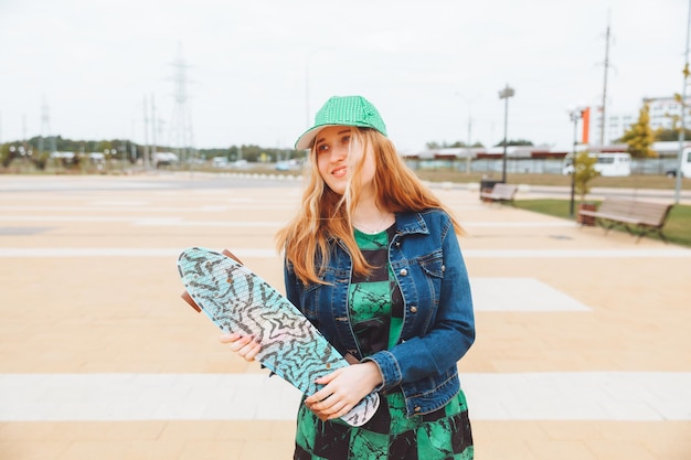 Foto de uma jovem linda caminhando ao ar livre com um adolescente de skate geração z