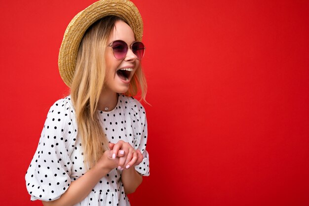 Foto de uma jovem loira atraente e sorridente, vestindo roupas casuais de verão e elegantes