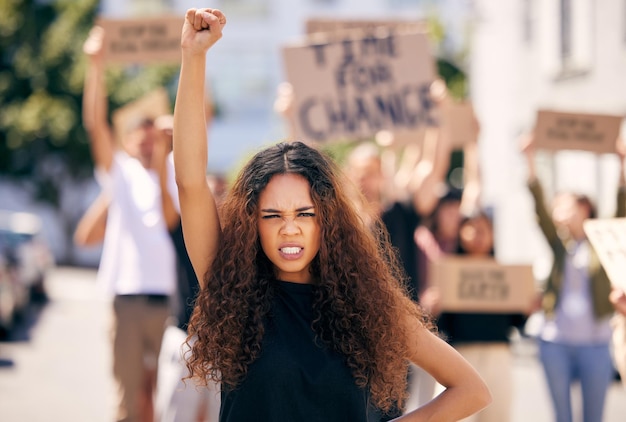 Foto de uma jovem manifestante em um comício com o punho levantado