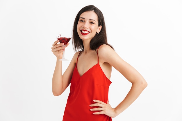 Foto de uma jovem mulher feliz e animada posando coquetel bebendo