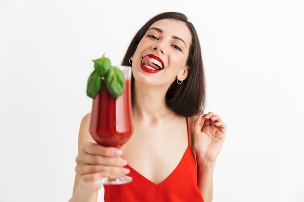 Foto de uma jovem mulher feliz e animada posando coquetel bebendo