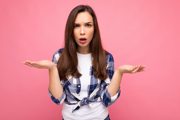 Foto de uma jovem mulher morena bonita com raiva e insatisfeita com emoções sinceras usando cheque da moda