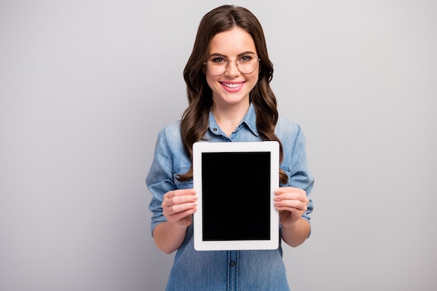 Foto foto de uma linda freelancer segurando um tablet e-reader demonstrando o novo modelo de gadget, preço baixo, especificações de desgaste.