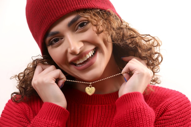 Foto foto de uma linda garota sorridente com colar de coração nas mãos e vestidos vermelhos e chapéu