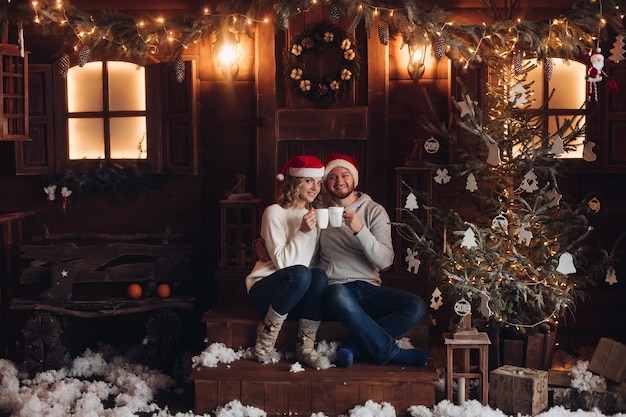 Foto foto de uma linda mulher caucasiana com o namorado celebrando o natal juntos em casa