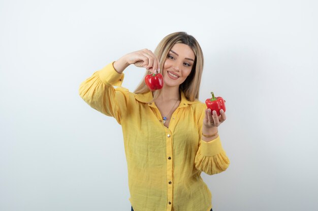 Foto de uma linda mulher loira posando com pimentões vermelhos