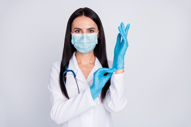 Foto de uma linda senhora médica vestindo luvas e usando máscara protetora de estetoscópio