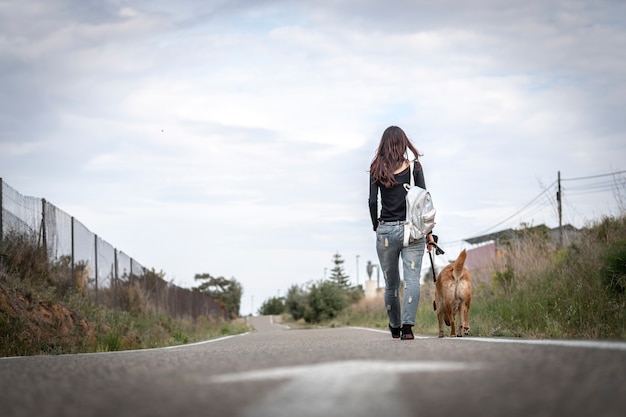 Foto de uma menina passeando com seu cachorro