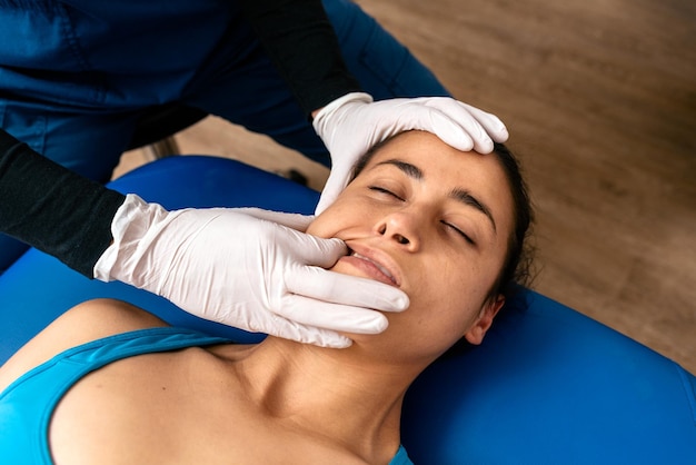Foto foto de uma mulher recebendo massagem facial enquanto estava deitada em uma maca