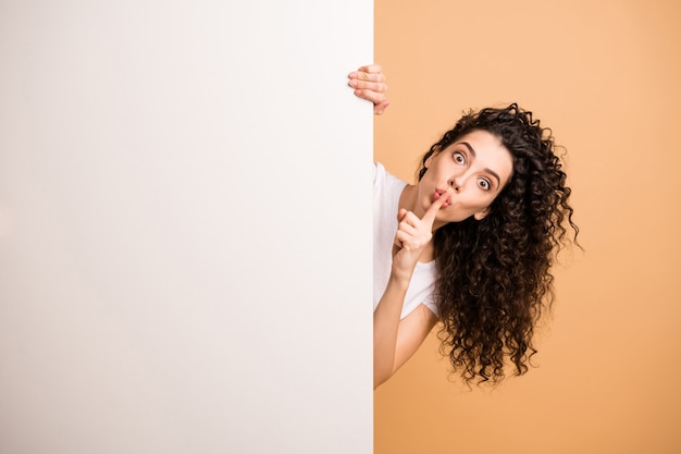 Foto de uma senhora incrível segurando um cartaz com uma faixa vazia pedindo ao cliente que não diga que sexta-feira é sobre os lábios, use roupas casuais brancas com fundo bege