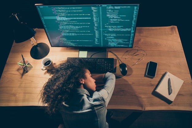 Foto foto de visão de alto ângulo da programadora adormeceu perto do monitor fazendo hora extra