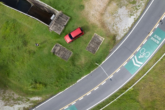 Foto de vista aérea vista de alto ângulo de cima para baixo do carro suv vermelho e estrada curva de asfalto