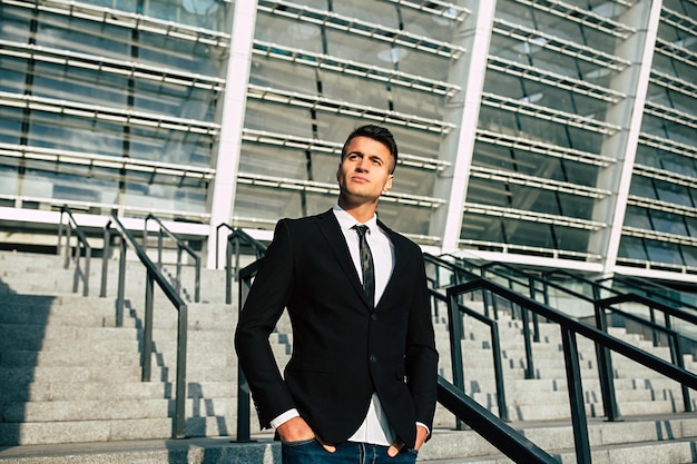 Foto de vista lateral do empresário confiante com roupa formal, olhando para longe enquanto descia as escadas