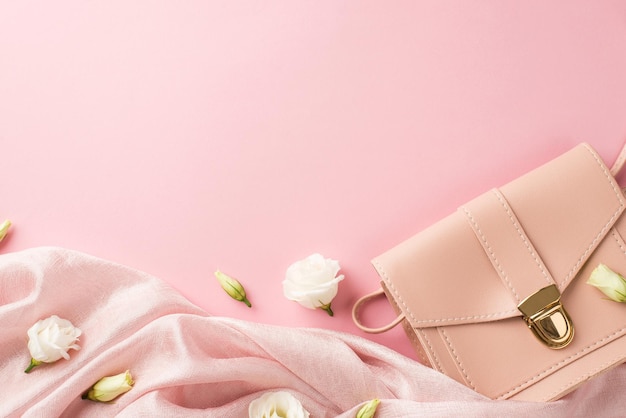 Foto de vista superior da composição do dia da mulher bolsa de couro rosa pano macio e botões de flores de genciana pradaria branca em fundo rosa pastel isolado com copyspace