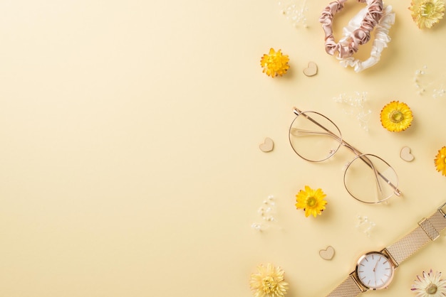 Foto de vista superior da composição do dia da mulher elegante óculos scrunchies relógio de pulso dourado corações e flores silvestres em fundo bege isolado com copyspace