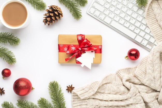 Foto de vista superior da xícara de teclado de bolas de árvore de natal vermelha bebendo quente galhos de pinheiro cone anis suéter aconchegante e caixa de presente com tag em forma de abeto em fundo branco isolado