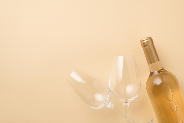 Foto de vista superior de dois copos de vinho e garrafa de vinho branco em fundo bege isolado com copyspace