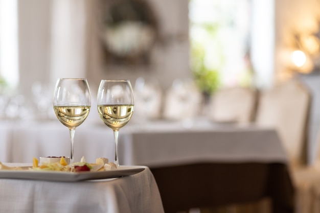 Foto der Flasche mit gießendem Champagner in Weingläsern auf grauem Hintergrund