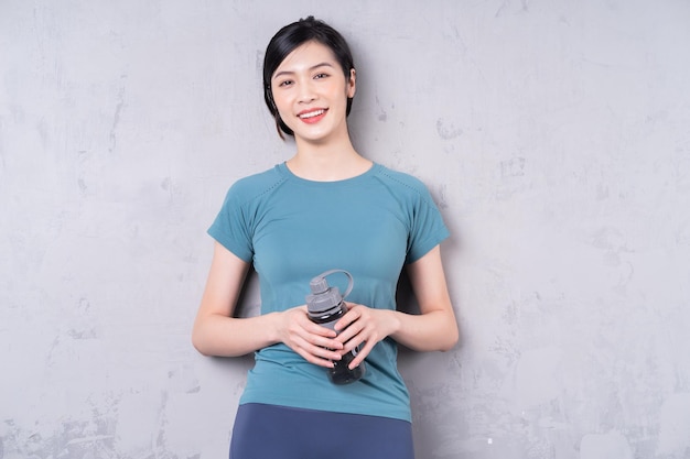 Foto der jungen asiatischen Frau, die Wasserflasche hält