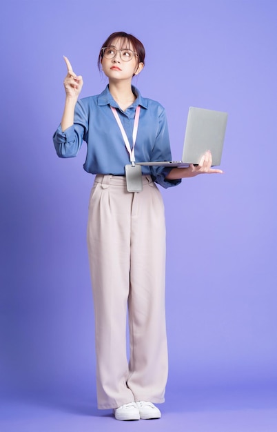 Foto der jungen asiatischen Geschäftsfrau, die Laptop auf Hintergrund hält