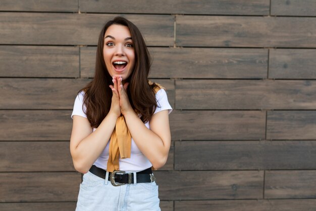 Foto der jungen emotionalen positiven attraktiven Brunettefrau, die stilvolle Kleidung trägt, die in der