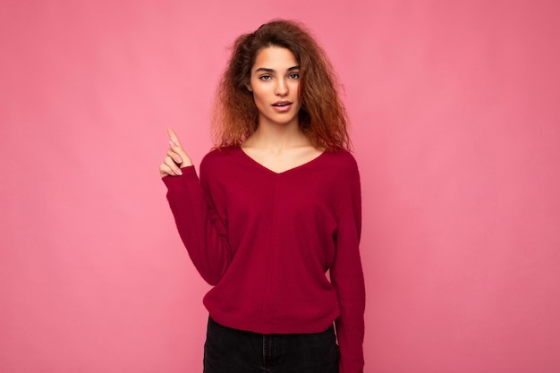 Foto der jungen schockierten schönen brünetten gewellten Frau mit aufrichtigen Emotionen, die lässiges Rosa trägt