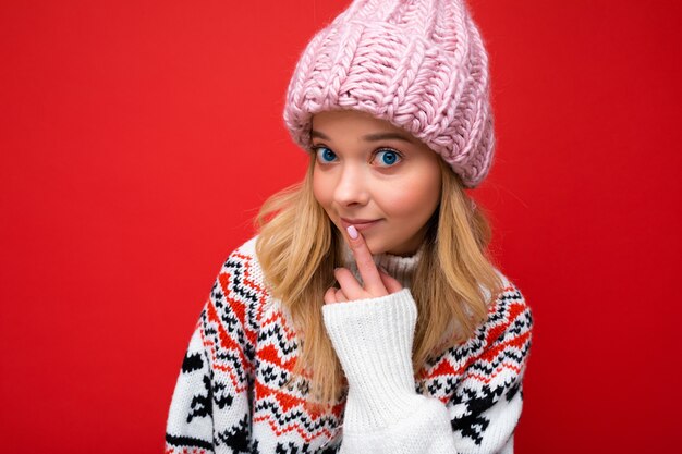 Foto der jungen schönen blonden dame mit aufrichtigen gefühlen, die rosa strickmütze und winter trägt