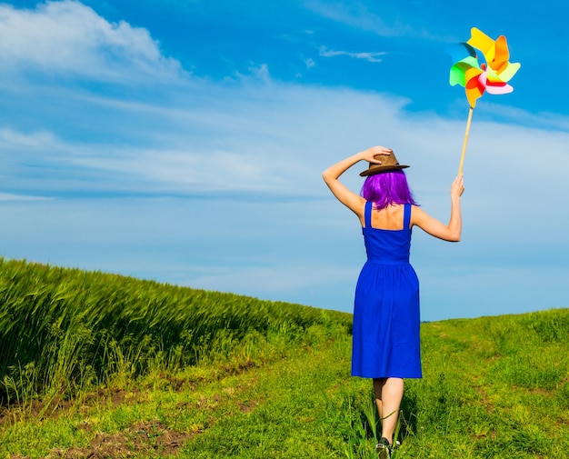 Foto der jungen schönen Frau mit Windrad im Feld