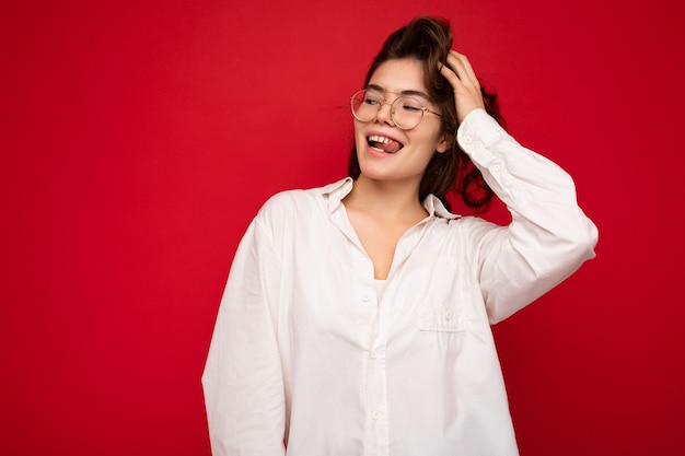 Foto der jungen schönen glücklichen lächelnden brünetten Frau mit weißem Hemd und optischer Brille sexy