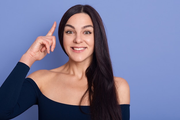 Foto der netten lächelnden Dame, die Kleid trägt, das ihren Finger im Eureka-Zeichen zeigt, mit großer innovativer Idee, Problemlösung habend.