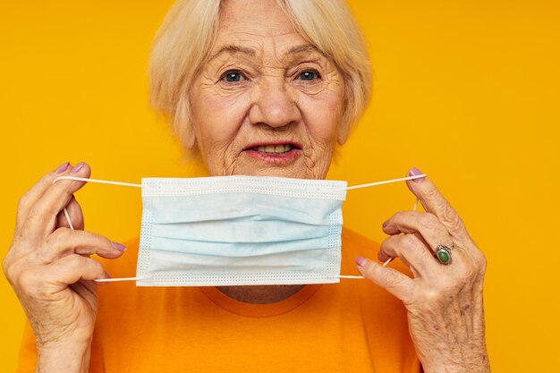 Foto der pensionierten alten Dame, glücklicher Lebensstil, medizinische Maske, isolierter Hintergrund