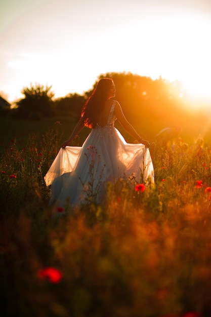 Foto der schönen glücklichen Frau im stilvollen Kleid, das im Weizenfeld lächelt