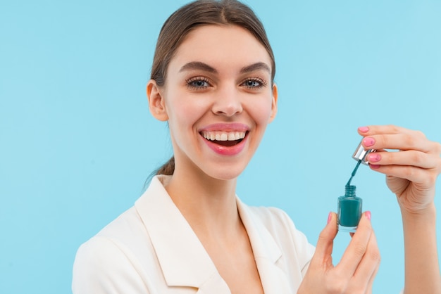 Foto der schönen jungen Frau, die lokal gehaltenen Nagellack aufwirft.