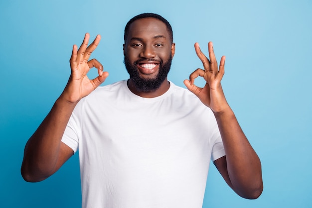 Foto des afrikanischen Mannes zeigt okey Zeichen auf blauem Hintergrund