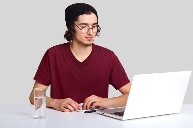 Foto des attraktiven Mannes mit dem lockigen Haar trägt schwarzen Hut