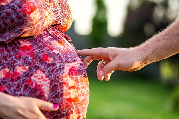 Foto des Bauches der schwangeren Frau Schwangerschaftsfinger gehen auf einen schwangeren Bauch Schwangerschaftskonzept
