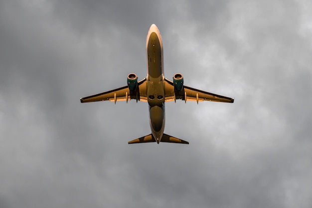 Foto des Flugzeugs, das in die grauen Wolken des Himmels fliegt