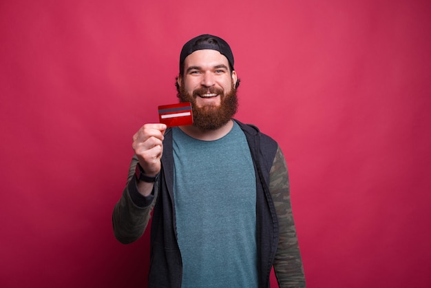 Foto des glücklichen Mannes, der seine neue Kreditkarte zeigt