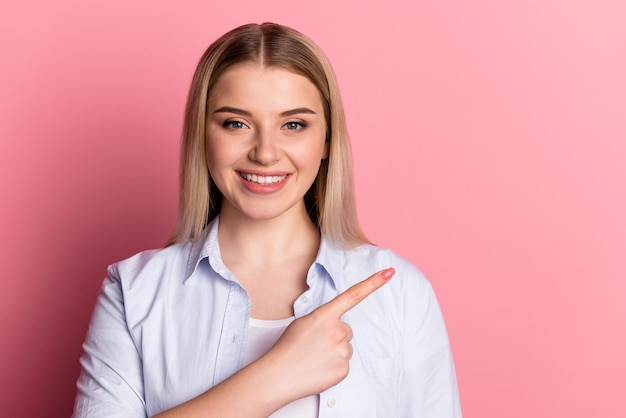 Foto des jungen Mädchens zeigt Finger leeren Raum Vorschlag entscheiden isoliert über rosa Hintergrund