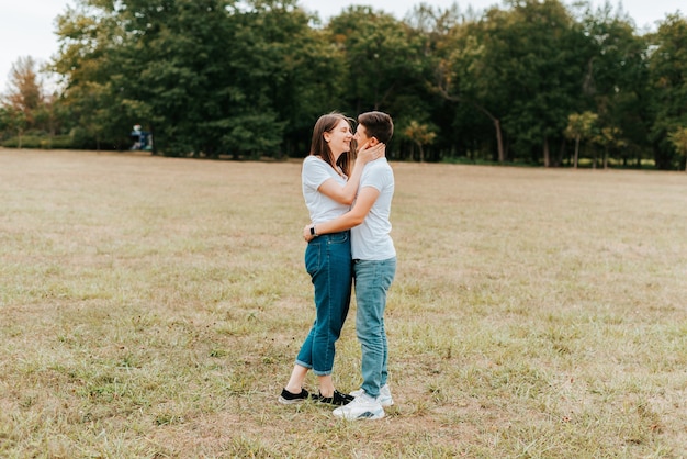 Foto des jungen Paares, das draußen im Park umarmt