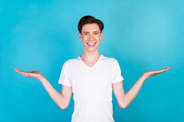 Foto des jungen Promotors, der die Lösungsentscheidung an den Händen hält, werben isoliert über blauem Farbhintergrund