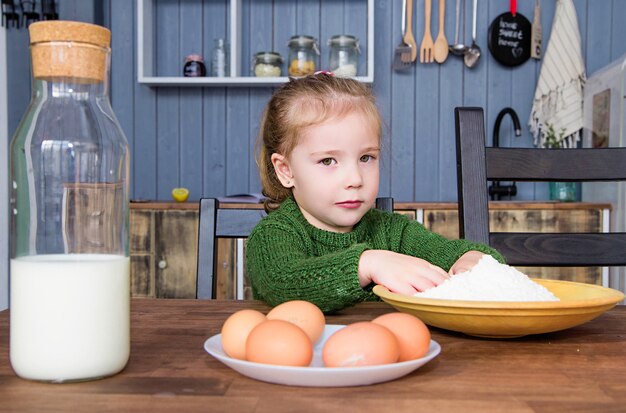 Foto des kleinen mädchens zieht ihre hände zum mehl