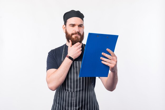 Foto des Kochmannes, der Bestandteile in den Notizen betrachtet