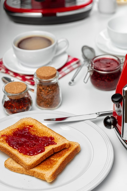 Foto des Küchentischs mit Toast, Fruchtmarmeladen und Messer