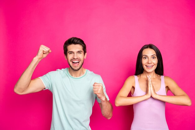 Foto des verrückten Paares Kerl und Dame, die Fäuste erheben, wollen Fußballmannschaft gewinnen Matchwettbewerb tragen Freizeitkleidung isoliert lebendigen rosa Farbhintergrund